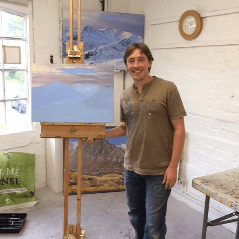 David DJ Johnson stood next to easel with partly finished painting