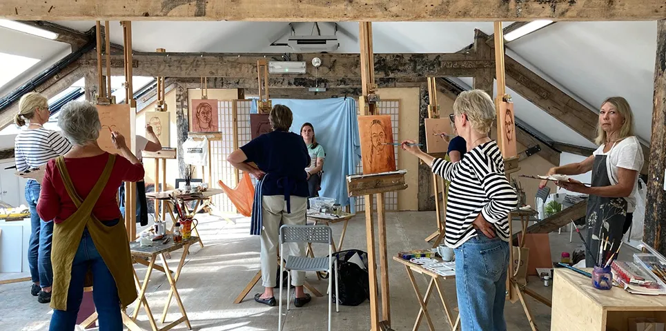 portrait painting workshop from life - students at easel in attic studio