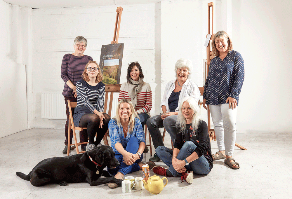 The Pegasus Art team sat and stood around easels and teaware with Digby the dog