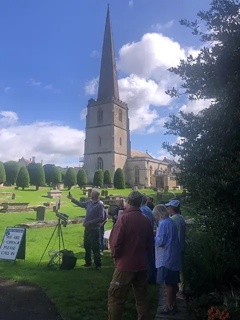 Roger Dellar showing students painting outside church in painswick
