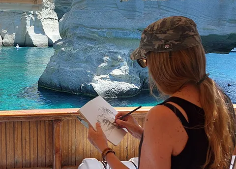 wendy rhodes sat drawing on holiday by white cliffs and blue sea