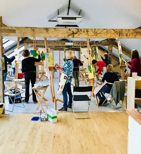 artists painting on easels in large studio space