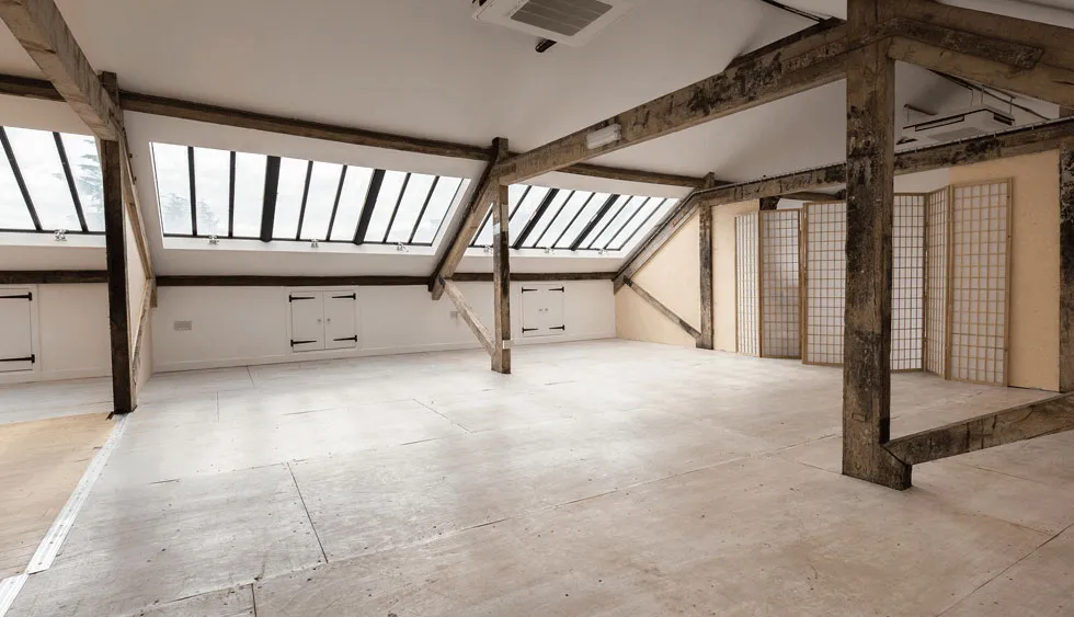 Attic Studio room for corporate hire - large light space with windows, cross beams and screen