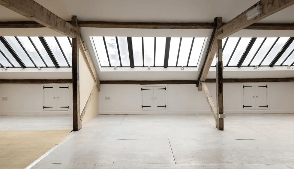 corporate hire space in attic with cross beams and eves cupboards