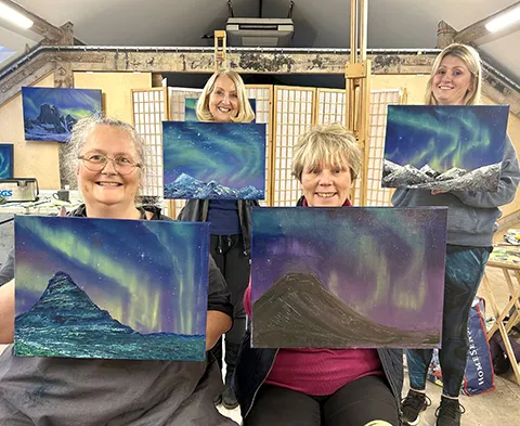 David Johnson workshop group of students holding their aurora paintings