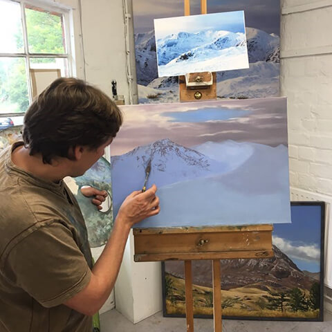 David Johnson DJ painting a winter mountain landscape on an easel