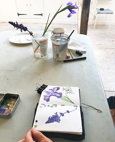 emma leyfield - sketchbook open on table with watercolour of iris