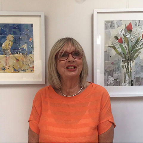 Helen Norman stood infront of framed collage on a white wall