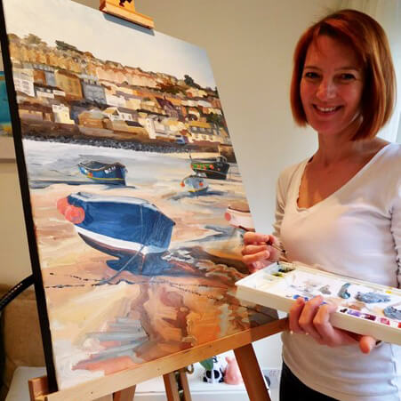 lucy burton stood infront of painting on easel holding a palette