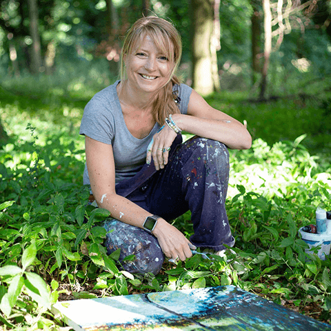 Mel Cormack-Hicks - sitting in front of painting in woodland